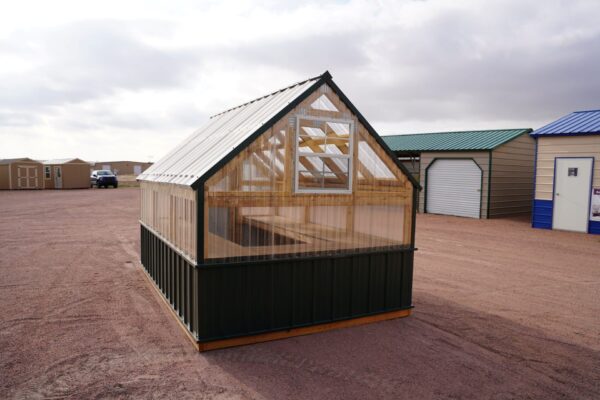 Back view of an 8x12 Green House with wood frame, green metal siding and roof, and plastic covering on the upper walls, highlighting the window in the back.