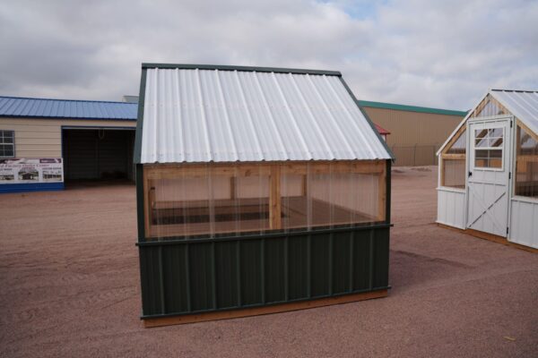Side view of an 8x8 Green House with wood frame, metal siding and roof, and plastic covering on the upper walls.