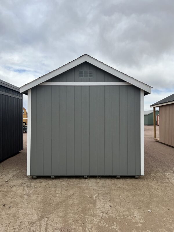 The sky is filled with clouds as a 10x20 Gable Style storage shed stands on the outdoor property with several other sheds in the background.