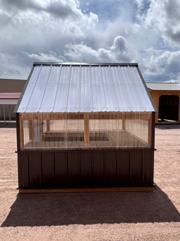The 8x8 Greenhouse shown from the side against a backdrop of the bright blue sky and fluffy white clouds.