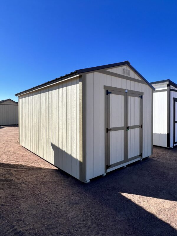Stunning left front corner view of the 10x16 Gable Style storage shed, featuring charming tan wooden walls. A versatile and stylish storage solution that harmonizes seamlessly with any landscape.