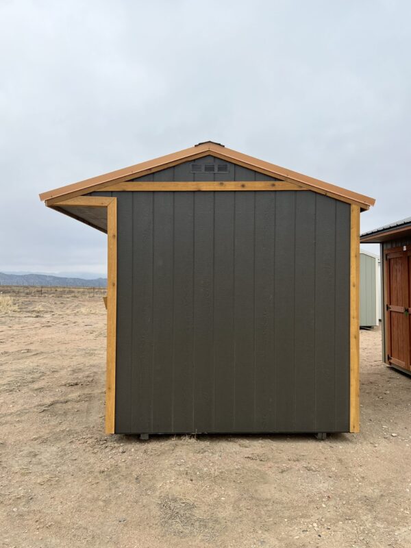 The sky stretches above a wooden shed on the sandy beach of the coastal shore.