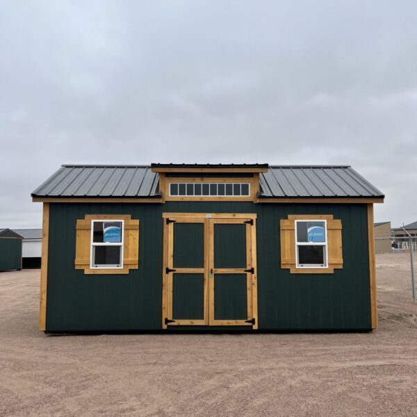 The sky is dotted with clouds as a building with a window and a property shed stands in the outdoor area of a house.