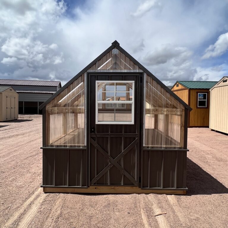 A view of the 8x8 Greenhouse, showing the large door in the front. In the background are several other storage sheds.